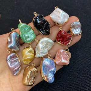 Close-up of assorted colorful irregular shell pendants with golden metal edges for DIY jewelry