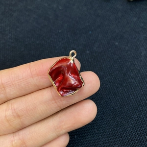 Close-up of red irregular shell pendant with gold plating for DIY necklace making