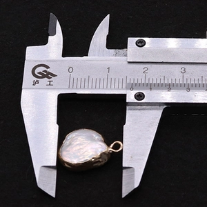 Macro-opname van een barokke parelhanger met gouden rand en maat van 15,5 mm
