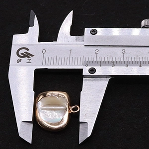 Detailed measurement of shell pendant connector with gold plated frame using digital calipers