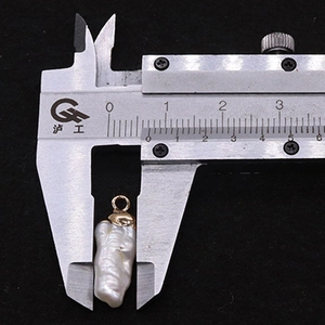 Detailed view of irregular baroque pearl pendant measured at 13mm with gold plated cap