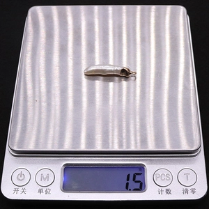 Digital scale showing the 1.5g weight of a baroque freshwater pearl pendant with gold cap