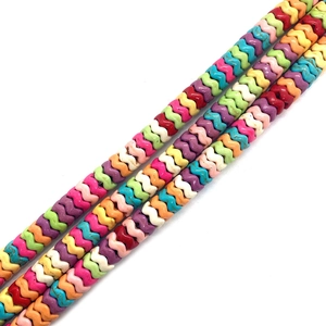 Nahaufnahme bunter wellenförmiger Türkisperlen für DIY-Schmuck in kräftigen Mischfarben