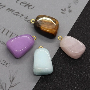 Macro shot of natural tiger eye and rose quartz stones with gold plated connectors