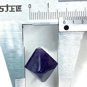 Macro shot of an octahedral deep purple amethyst crystal measured with a caliper