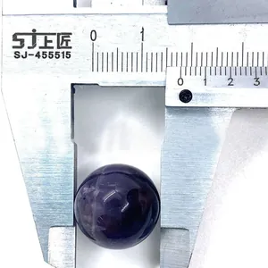 Macro shot of 18mm round purple amethyst gemstone measured with a metal caliper