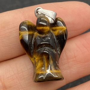 Détail macro du pendentif ange en pierre d'oeil de tigre avec grain naturel et fermoir en argent