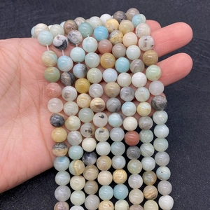 Detailed view of mixed natural amazonite stone beads held in hand for jewelry making