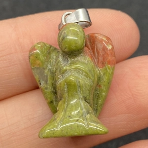 Vue détaillée d'un pendentif ange en pierre unakite naturelle tenu à la main avec détails