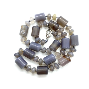 Macro detail of gray purple agate necklace with cylinder beads and silver lobster clasp