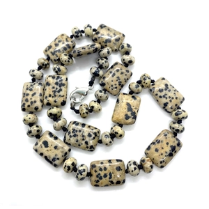 Détail des perles en jaspe dalmatien et du fermoir mousqueton sur un collier artisanal