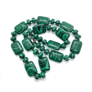 Détail macro de perles de malachite rectangulaires et d'intercalaires ronds pour bijoux