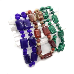 Perles en pierre naturelle 13x18mm en violet, marron et vert sur clôture blanche