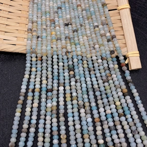 Close-up of natural faceted amazonite stone beads on a bamboo tray for jewelry making