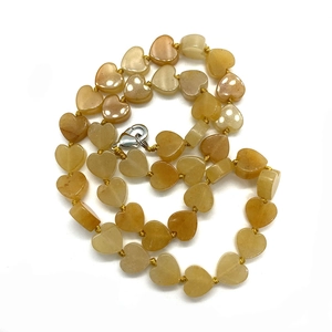 Collana di perle a cuore giallo miele con chiusura a moschettone argento su fondo bianco