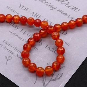 Polished natural red agate round beads for DIY jewelry making on grey card