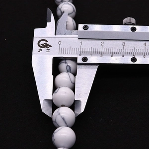Vista macro de cuentas de turquesa blanca de 8mm con textura jaspeada para joyería DIY