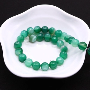 Natural green striped agate round beads for DIY jewelry making on white petal plate