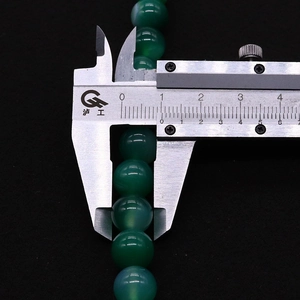 Detailed measurement of 8mm green striped agate beads with a digital caliper
