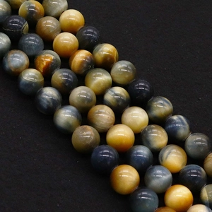 Macro shot of tiger eye beads with natural chatoyancy on black textured background