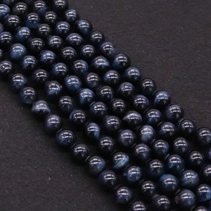 Macro detail of polished blue tiger eye stone beads with natural chatoyant wavy texture