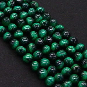 Macro shot of polished green cat eye stone beads with silky luster for jewelry making