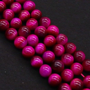 Macro shot of 8mm rose red tiger eye stone beads with cat eye effect for DIY jewelry