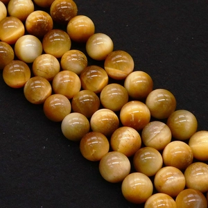 Macro detail of natural yellow tiger eye beads with polished texture for DIY jewelry making