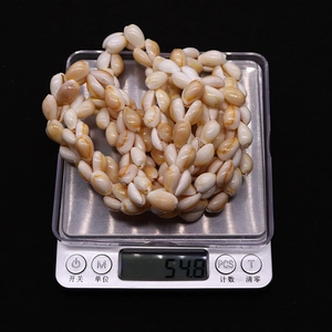 Makroaufnahme natürlicher Spiralmuschelperlen auf einer Waage mit Gewichtsangabe