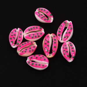 Close-up of eight handmade natural cowrie shells with pink edges and green polka dots