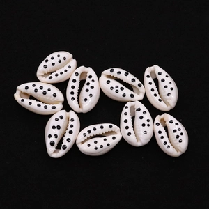 Close-up of white cowrie shells with black polka dot patterns for DIY jewelry making
