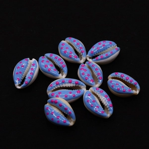 Macro shot of natural cowrie shells with pink polka dots for DIY jewelry making