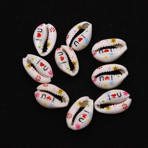 Macro detail of cut natural cowrie shells with floral and I Love You prints for jewelry