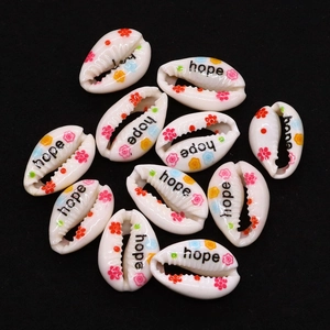 Macro shot of natural seashell beads with hope lettering and floral patterns for DIY jewelry