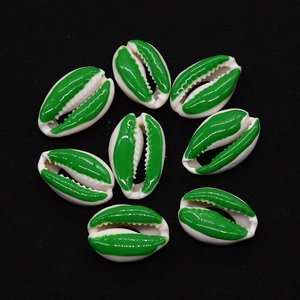 Nahaufnahme grüner und elfenbeinfarbener Kauri-Muscheln für DIY-Schmuck und Halsketten