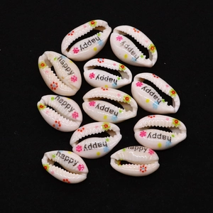 Detailed view of white cowrie shell beads featuring colorful flowers and happy text