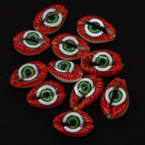 Dettagli macro di perline in conchiglia di ciprea rossa con motivi Evil Eye per gioielli