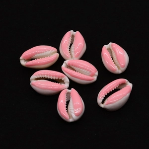 Makroaufnahme von natürlichen Kaurimuscheln mit rosa Emaille für DIY-Schmuckzubehör