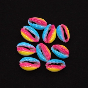 Macro detail of rainbow gradient cowrie shell beads for DIY jewelry making on black background