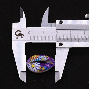 Detailed view of daisy pattern natural shell beads measured by caliper for DIY jewelry