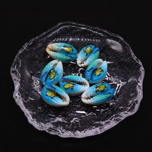 Detailed view of hand-painted turtle motifs on natural seashell beads for DIY jewelry