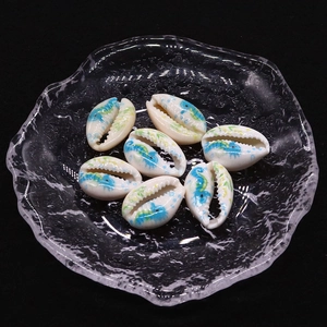Detailed macro view of seven hand-painted natural cowrie shell beads for DIY jewelry making