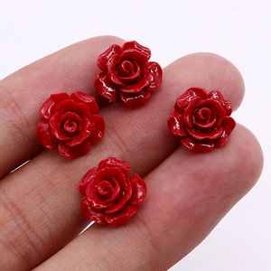 Classic 10mm red rose synthetic coral stud earrings shown on finger for size reference