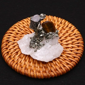 Detail of amethyst gemstone miner statue with tiger eye and raw crystal cluster base