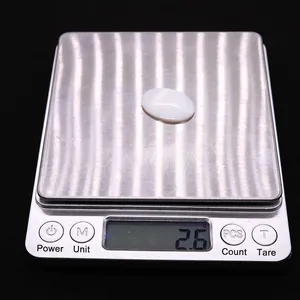 Vista macro di una perla di conchiglia ovale bianca da 2,6g su bilancia digitale