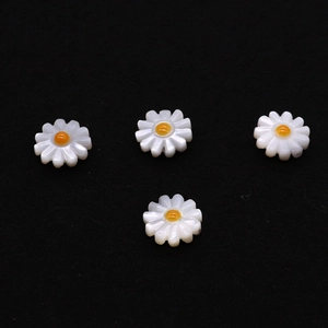 Makro-Detail von vier weißen Gänseblümchen-Perlen mit gelber Mitte für DIY-Schmuckherstellung