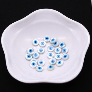 Natürliche runde Muschelperlen mit bösem Blick für DIY-Schmuck in Keramikschale