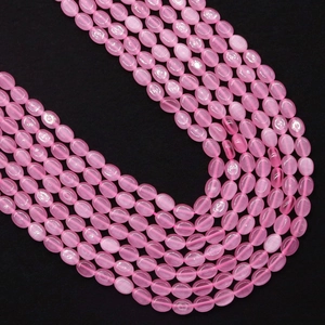 Macro-opname van roze kattenoog steen ovalen kralen met zijdeglans voor DIY-sieraden