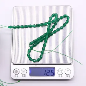 Vista macro che mostra il peso di 12,5g di perline a goccia sfaccettate in occhio di gatto