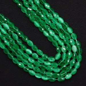 Macro-opname van gefacetteerde ovale smaragdgroene kattenoogstenen voor sieraden